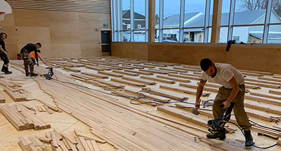 Poseurs de planchers sportifs dans un gymnase