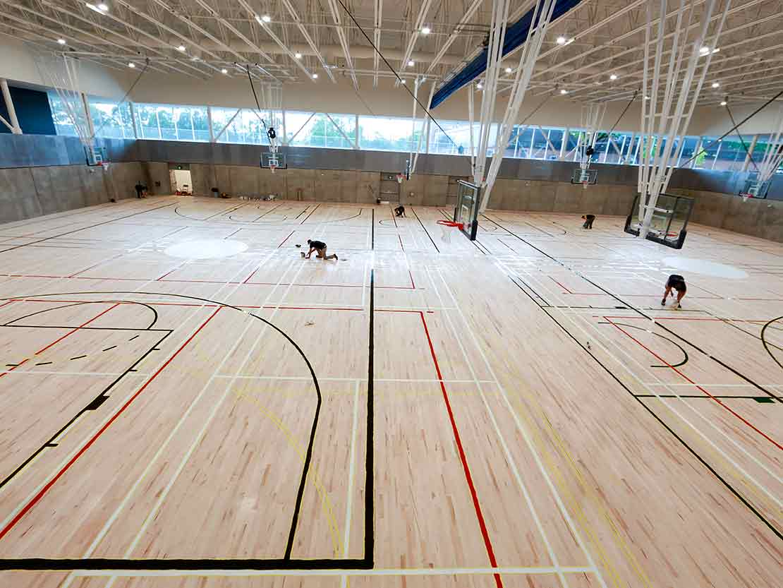 Marquage de lignes d'un plancher de gymnase vu de la passerelle