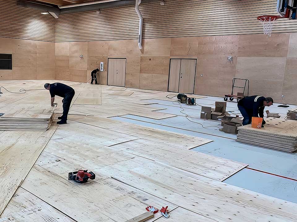 Pose de plancher de bois sportif dans un gymnase